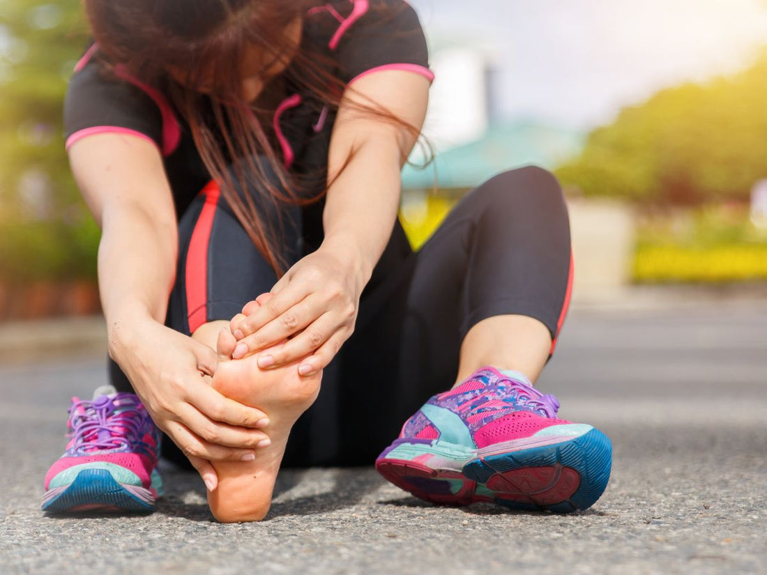 Woman sitting down after running because of extreme foot pain