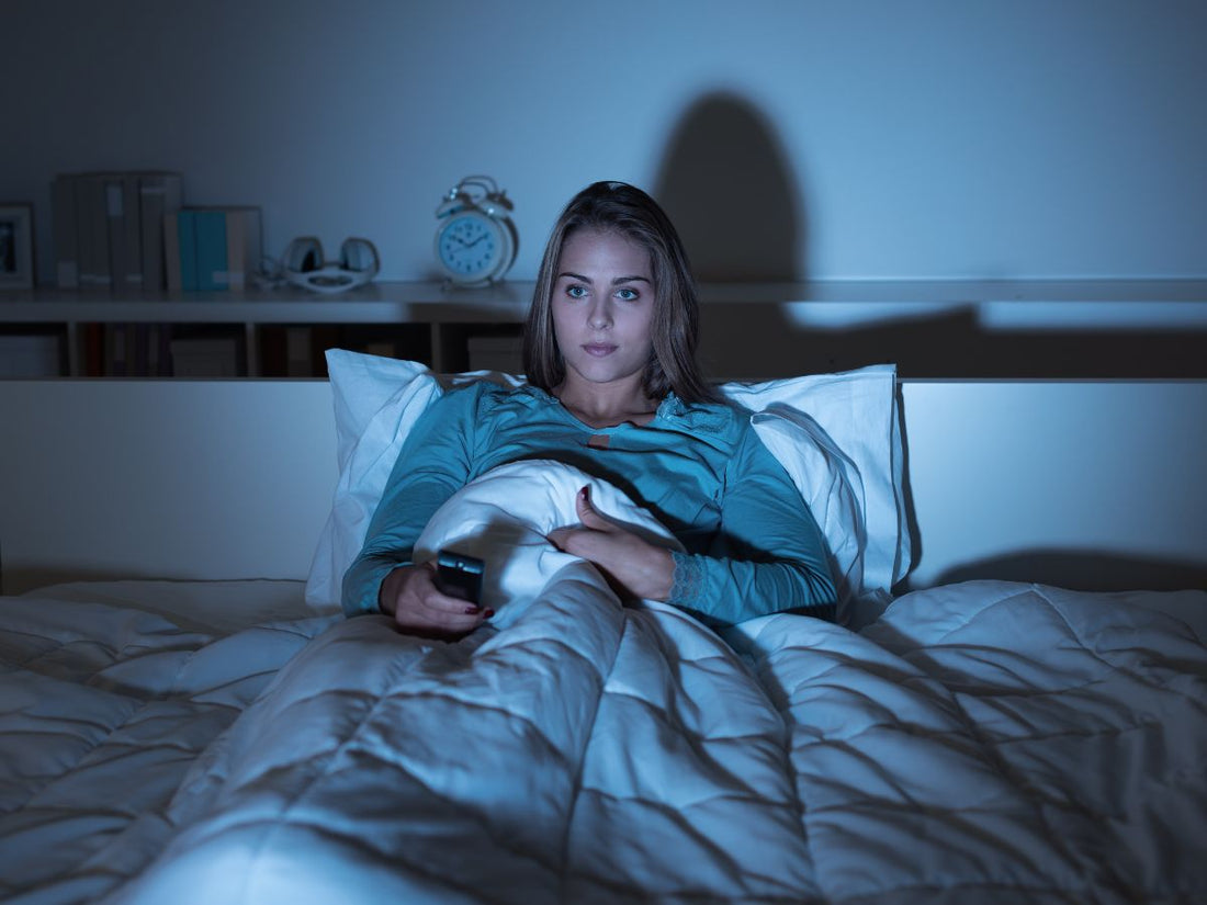 A woman watching TV before sleep